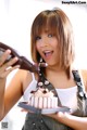 A woman holding a plate with a cake on it.