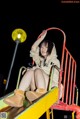 A woman sitting on top of a slide at night.