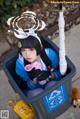 A woman sitting in a trash can holding a toy gun.