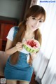 A woman holding a slice of watermelon in her hand.