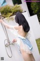 A woman in a blue and white lingerie taking a shower.