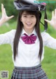 A young woman in a school uniform with a hat on her head.