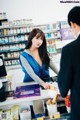 A woman standing at a counter in a pharmacy.