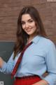 A woman in a blue shirt and red skirt posing for a picture.