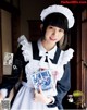 A woman in a maid outfit holding a bunch of cards.