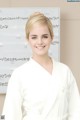 A woman in a white robe standing in front of a whiteboard.