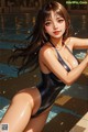 A woman in a black bathing suit sitting by a pool.