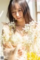 A woman holding a bunch of flowers in her hands.